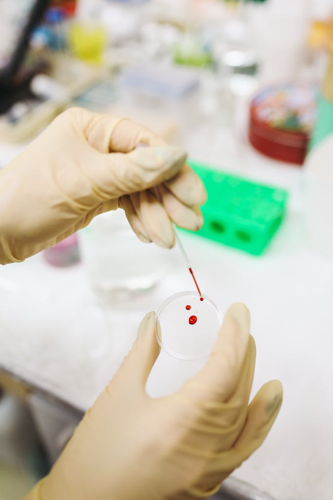 Close-up of a scientist's hands in gloves analyzing a blood sample in a laboratory setting.